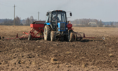 Farm tractor plowing a field on a sunny day in rural countryside