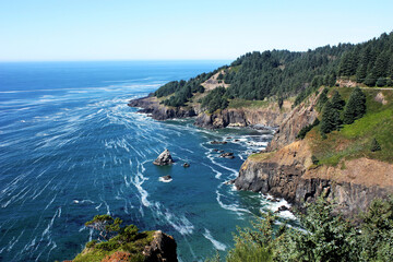 Rocky Oregon Coastline with Blue Ocean and Forested Cliffs