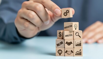 Businessman stacking wooden block with gear icon on top of a pyramid of business concept blocks