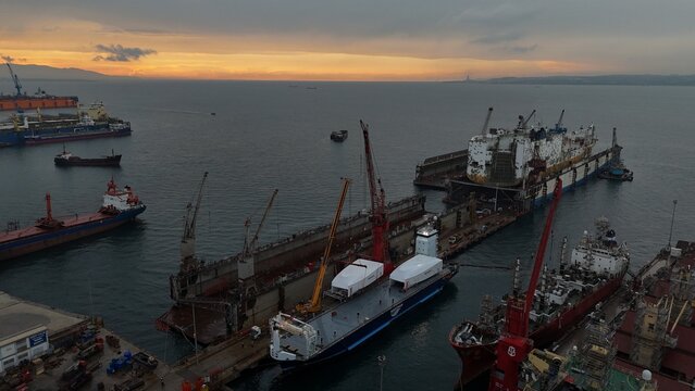 Industrial footage of shipbuilding and maintenance operations at Yalova shipyard in T&uuml;rkiye. Workers and heavy equipment handle marine vessels, showing maritime engineering, repair, and construction p