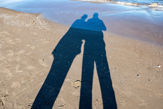 Sombras en la playa de una mujer y un hombre