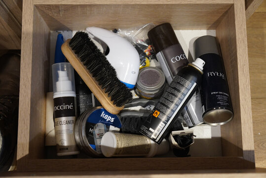 Shoe care products neatly organized inside a wooden drawer for easy access