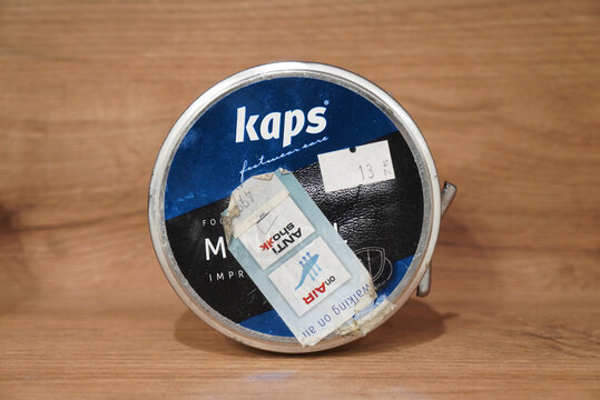 Kaps footwear care product with Anti Shock technology on a wooden surface