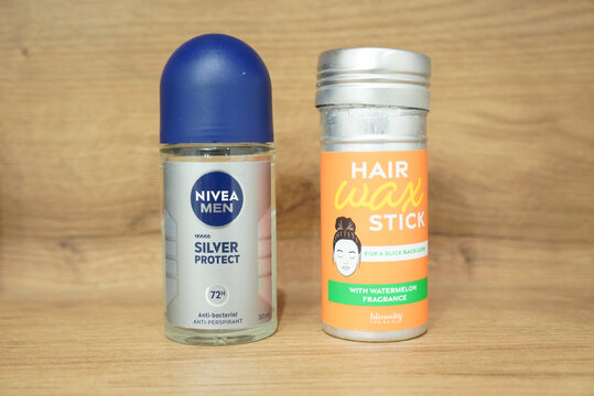 Deodorant and hair wax stick on a wooden surface, product photography.