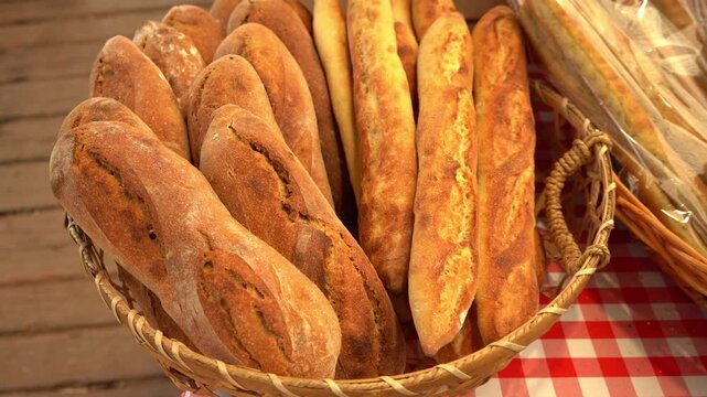 Golden and rustic baguettes arranged in a woven basket, showcasing crust textures and traditional French bread charm in warm natural light.

