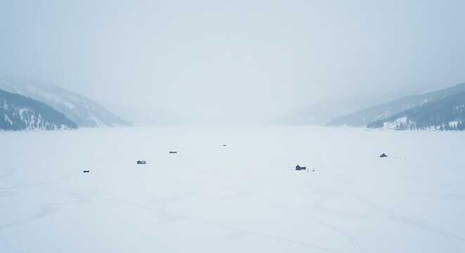 Cold winter day on frozen lake surrounded by snow covered mountains - Powered by Adobe