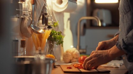 In a cozy kitchen, hands skillfully slice vibrant red pepper on a wooden cutting board as evening light filters in. This scene captures the joy of preparing a meal with fresh ingredients - Powered by Adobe