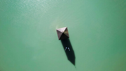 Aerial view of alpine turquoise lake with pavilion and paddle boards