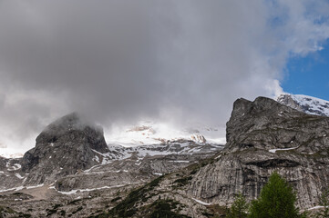 Marmolada mountain range seen from the viel del pan trail during a summer cloudy day, Canazei, Dolomites, Italy