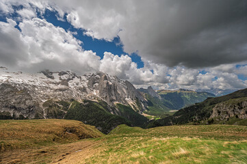 Fototapeta premium Marmolada mountain range seen from the viel del pan trail during a summer cloudy day, Canazei, Dolomites, Italy