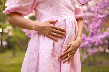 Pregnant Woman in Pink Dress Holding Her Belly