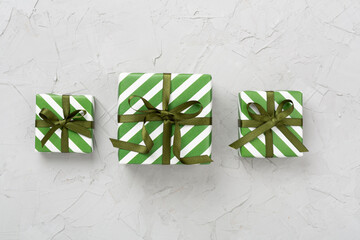 Striped Christmas gift boxes on concrete background, top view