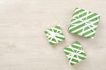 Striped Christmas gift boxes on wooden background, top view
