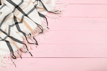 Plaid cashmere scarf on wooden background, top view