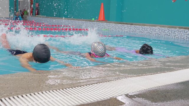 Children learning swimming techniques in a pool class