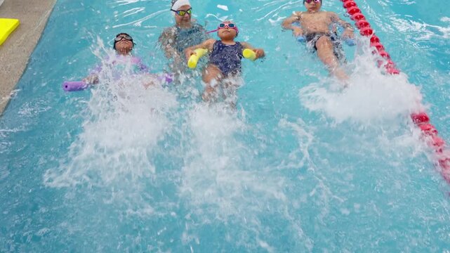 Children learning to kick on their backs during a swimming lesson