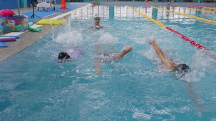 Children learning front crawl technique during swimming lessons