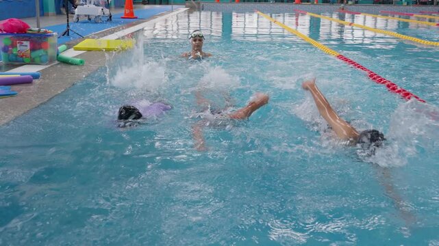 Children learning front crawl technique during swimming lessons