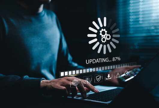 Software Update and System Upgrade Concept. Person holding phone while using laptop with software update progress interface and security, technology maintenance, application upgrades, system security.