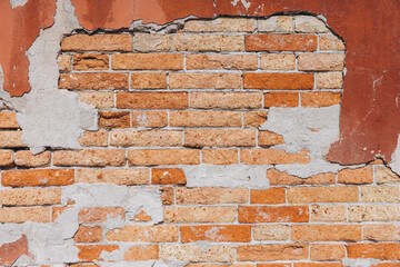 Old brick wall with decaying plaster in Venice