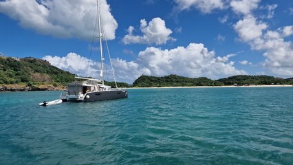 Small boat on turquoise sea with beach in the background