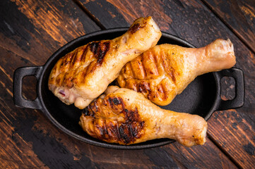 Tender grilled poultry drumsticks, showcasing a smoky aroma and mouthwatering glaze that tempts the taste buds. wooden background. top view
