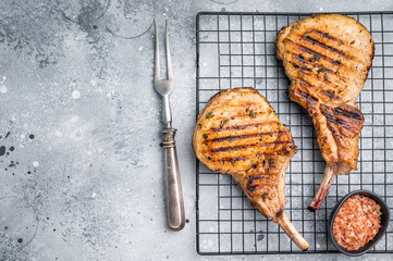Juicy grilled pork Tomahawk chop, perfectly seared and bursting with flavor, ideal for a hearty feast. grey background. top view