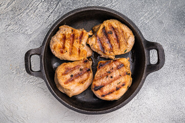 Juicy grilled pork medallions steaks, perfectly seared tenderloin meat for a flavorful bite, ideal for any gourmet meal. grey background. top view