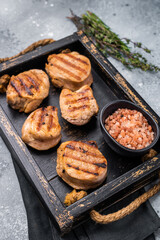 Tender char grilled pork medallion steak, perfect for adding a touch of elegance to your dinner plate.grey background. top view