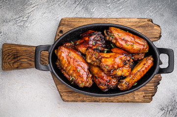Grilled chicken wings smothered in sweet and sour sauce, poultry meat. white background. top view
