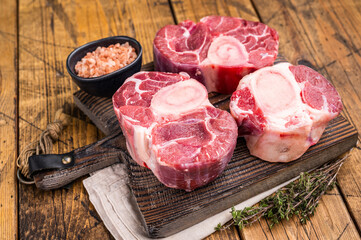 Fresh raw ossobuco, osso buco meat, showcasing tender veal shank with rich marrow, perfect for gourmet Italian dishes. wooden background. top view