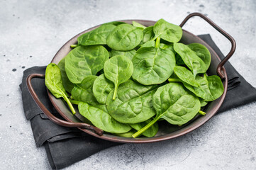 Vibrant fresh spinach leaves, perfect for salads, smoothies, or healthy cooking, bursting with nutrients. grey background. top view