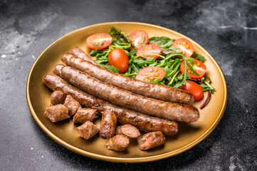 Close up of perfectly charred grilled sausage with salad, ideal for adding flavor to your favorite dishes or sandwiches. black background. top view