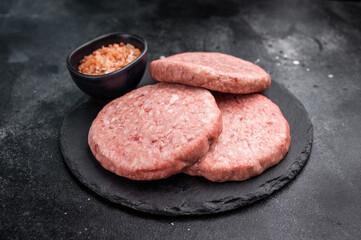 Fresh raw beef meat patty ready for grilling, perfect for homemade burgers and delicious family meals.black background. top view