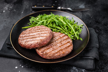 Grilled beef and pork meat patty paired with fresh veggies, an essential component for gourmet burgers. black background. top view