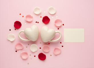 valentine flat lay with white heart sweets, rose petals and blank card on pink background