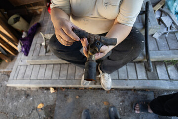 A man holds a complex section of rusty metal water pipe, demonstrating its components and wear, focusing on plumbing repair and maintenance. A demonstration of an old water pipe.