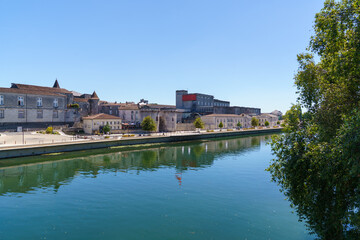 The embankment of the Charente River in the city of Cognac France Several buildings of the famous Cognac house are visible along the embankment