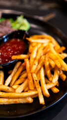 Carne asada servida con papas fritas y salsa en restaurante nocturno