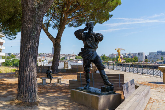 A black iron or bronze monument in Nantes. The monument to Captain Nemo The city limits of Nantes are visible in the background The photo was taken in August 2022