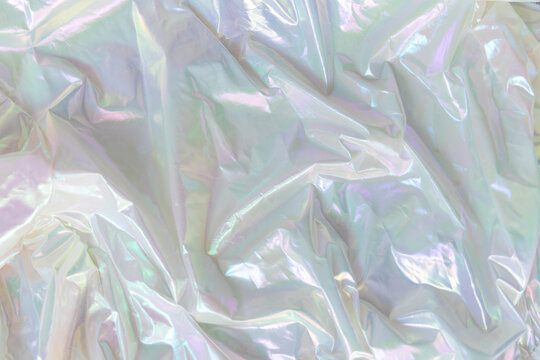 Shiny holographic fabric with smooth folds and iridescent light reflections. Abstract background with metallic texture and soft pastel colors. - Powered by Adobe