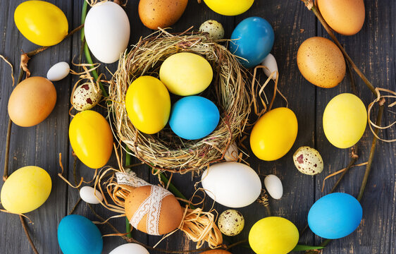 Colored Easter eggs blue yellow in eggs nest background, poster, banner, layout space for text, advertising, web, social media. Happy Easter card flyer, template card frame typography design