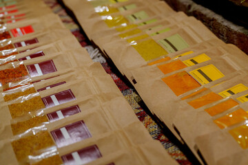 Colorful packets of ground spices arranged in rows on market stall