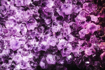 Vibrant amethyst crystal cluster with deep purple facets and sparkling geometric formations