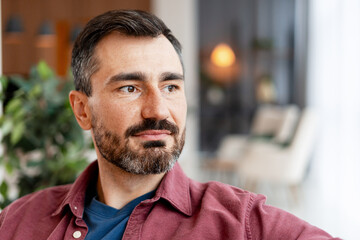 Pensive middle aged man looking away in casual wear indoors