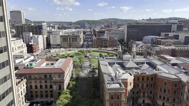 Drone flies south down Paul Kruger Street toward Church Square on sunny day in Pretoria, South Africa