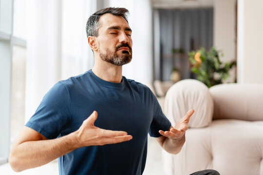 Bearded middle aged man meditating at home finding inner peace and balance - Powered by Adobe