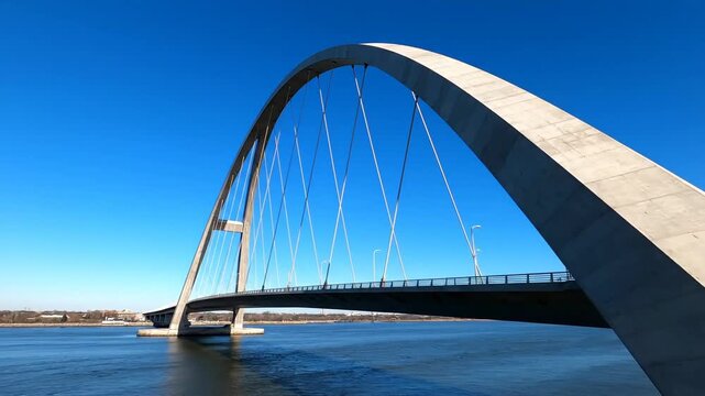 Modern arch bridge structure against bright blue sky
