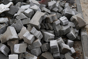 Paving stones are dumped in a pile at a construction site, creating a mess