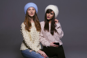 Vibrant and Energetic Portrait of Two Female Models with Bright Smiles and Perfect Teeth, Posing in Warm Woolen Accessories for an Autumn or Winter Seasonal Campaign